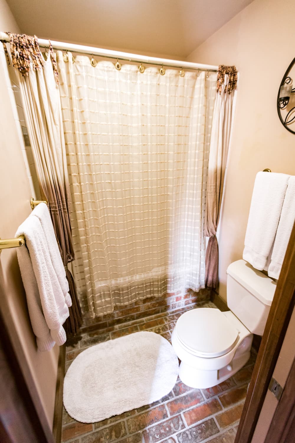 Bathroom with shower-tub combo, faux brick floor