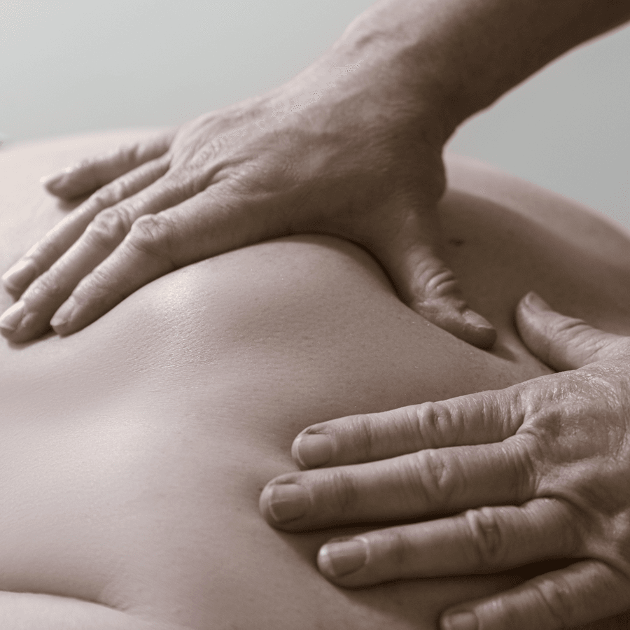 A pair of hands applying pressure to a person's back during a massage.
