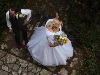 Bride twirling in her wedding dress as groom looks on